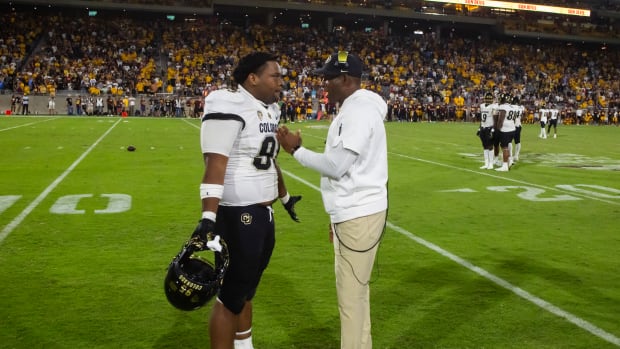Colorado Buffaloes head coach Deion Sanders talks to defensive lineman Bishop Thomas (95) against the Arizona State Sun Devils at Mountain America Stadium